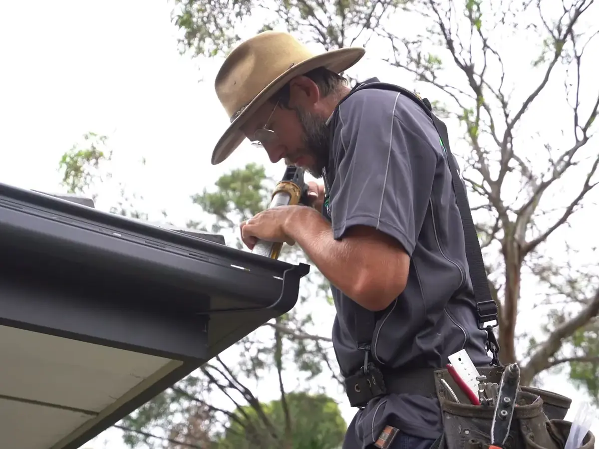 LifeProof roof plumber fixing a new Colorbond gutter at the roof edge