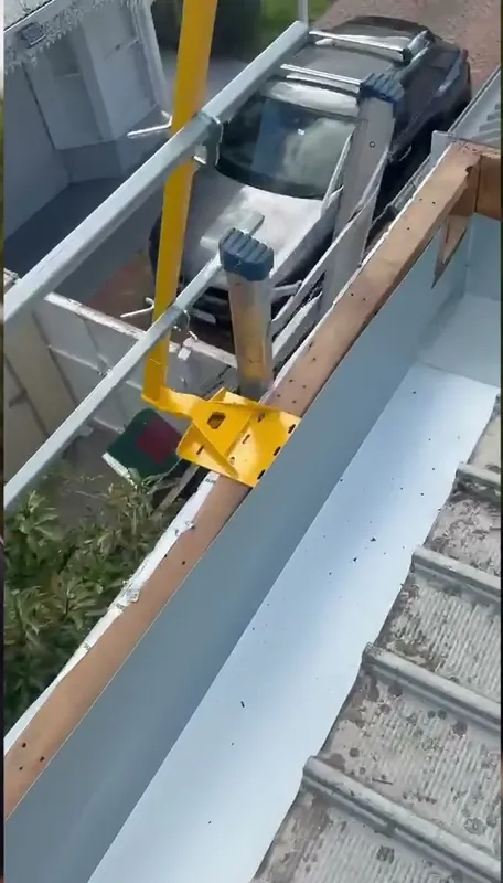 New metal box gutter being fitted beside the roof