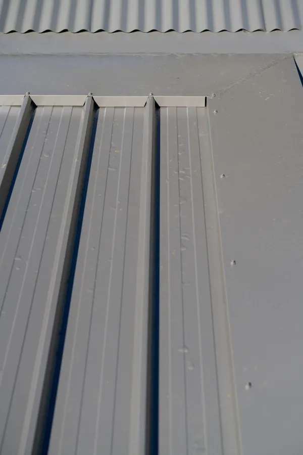 Close-up of new metal roof sheeting ribs and flashing