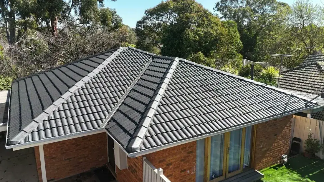 The same roof after restoration, coated in charcoal with white ridges