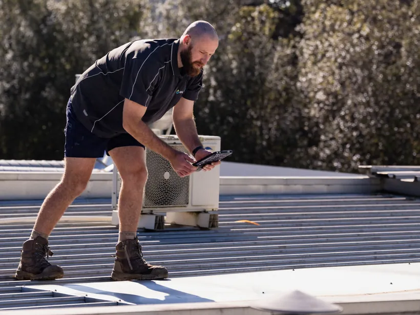 Roof plumber inspecting a roof penetration