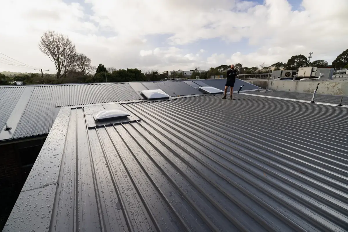 New metal roof with skylights, roofer on the ridge